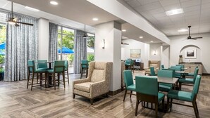A spacious indoor dining area with high ceilings, large windows, and a mix of seating arrangements. - Santa Barbara | Romantic Beach Retreat | Pool + Beach (Pompano Beach)