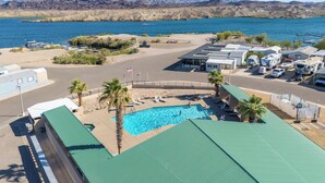 A campground with RVs, a swimming pool, and a view of a lake and mountains. - Live on Island Time on Beachcomber Blvd, Lake Havasu City (Lake Havasu City)