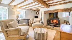 A cozy living room with exposed wooden beams, a fireplace, and comfortable seating. - Cottage Sleeps 6 With Parking and Garden (Shipston on Stour)