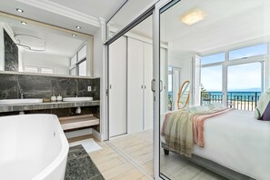 Ein modernes Badezimmer mit freistehender Badewanne, zwei Waschbecken und einem großen Spiegel.