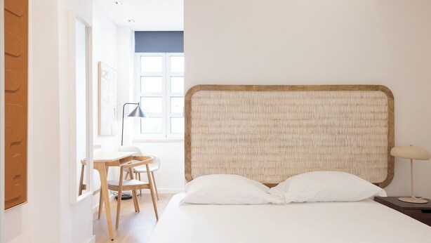 Un dormitorio con cama, escritorio y silla.