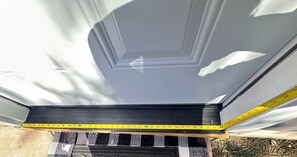 Une fenêtre à cadre noir, avec un mètre ruban indiquant sa largeur.