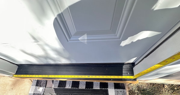 A black-framed window with a measuring tape indicating its width.