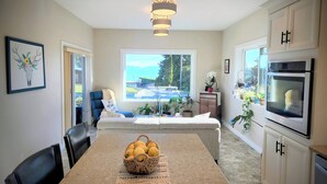 Uma cozinha moderna com área de refeições, uma janela grande com vista e um lustre.