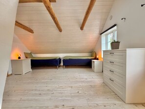 A bedroom with two beds, a dresser, and a window. - Large, lovingly renovated farmhouse – nature, hot tub, sauna, and boat (Olofström)