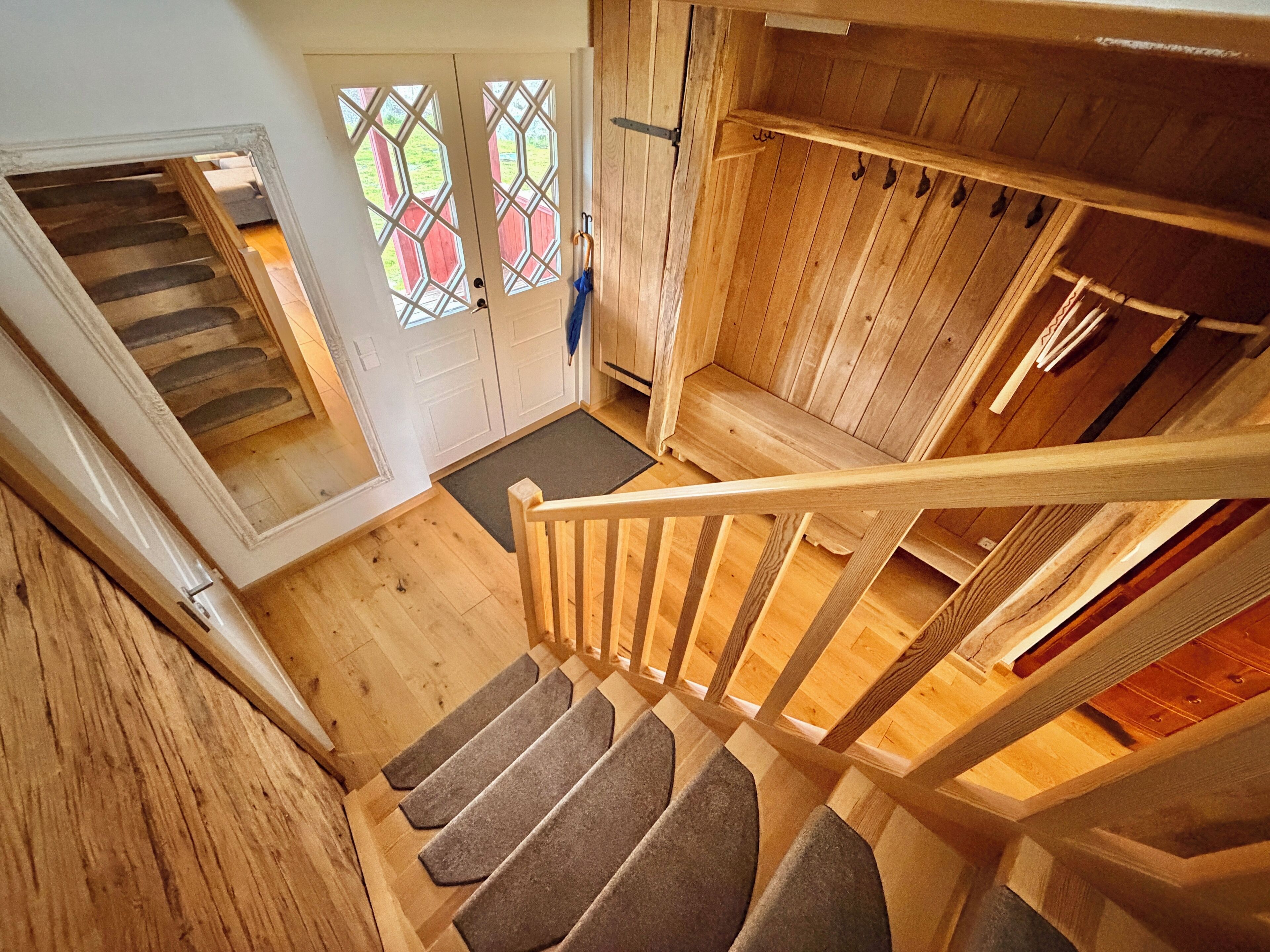 A wooden staircase with carpeted steps leading to a landing.