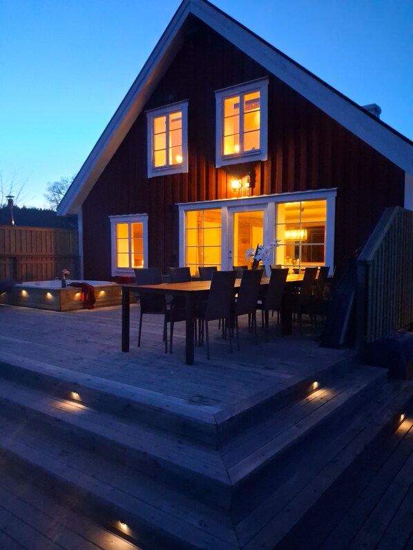 Een houten huis met een eethoek en een trap naar de ingang.