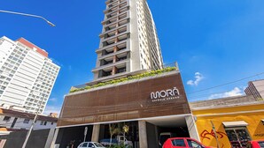 A tall building with a modern design, featuring a prominent 'MORA' sign on the facade. - Edifício Morá (Curitiba)