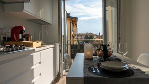 A modern kitchen with a dining area, a view of buildings, and a balcony. - From Kri•Modern design - 10 min Orio al Serio airport Bergamo - Self check in (Seriate)