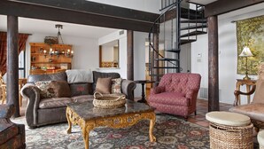 A spacious living room with a high ceiling, a staircase, and a chandelier. - Lakefront Home w/Views, Huge Deck, Family-Friendly (Lago Vista)