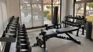 A gym with exercise equipment, large windows, and a view of the outdoors. - Modern Luxury Escape BTS Udom Suk 0m (Bangkok)