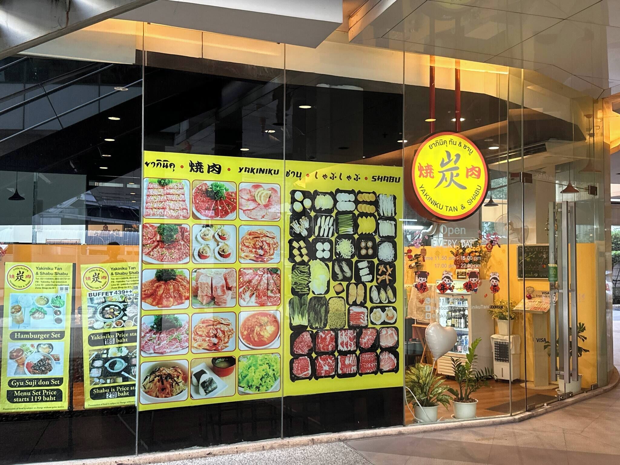 A restaurant with a glass facade, menu boards displaying food items, and a sign indicating the restaurant's name.