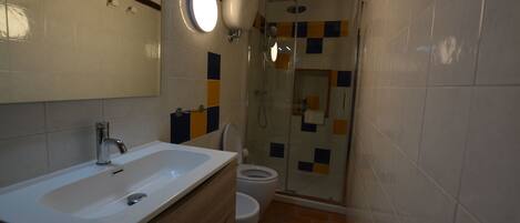 A bathroom with a sink, toilet, and shower.