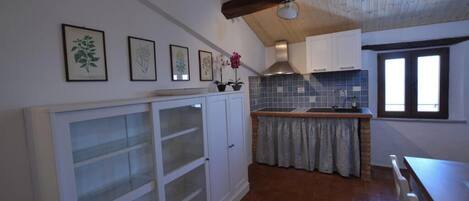 A kitchen with white cabinets, a tiled backsplash, and a wooden ceiling.