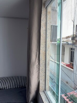 A room with a bed, a window, and a view of the outside. - BEST DEAL FOR RIO (Rio de Janeiro)