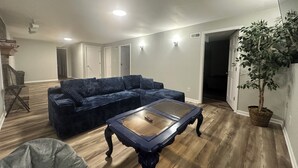 Una sala de estar con un sofá azul, una mesa de centro y una planta en maceta.