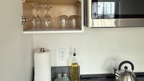 A kitchen with a built-in microwave, a kettle, a roll of paper towels, and a shelf with glassware. - Hilltop Hideaway – Peaceful 2BR Suite, Near Beach Access and Mt. Baker Sunrises (North Saanich)