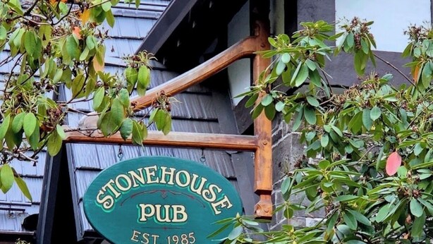 A stone building with a pub sign, a wooden staircase, and a metal sun decoration. - Hilltop Hideaway – Peaceful 2BR Suite, Near Beach Access and Mt. Baker Sunrises (North Saanich)