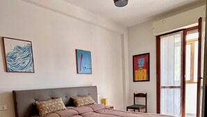 A bedroom with a large bed, a ceiling light, and artwork on the walls. - Soleja House, 1000 meters from Poetto beach and Molentargius Park (Quartu Sant'Elena)