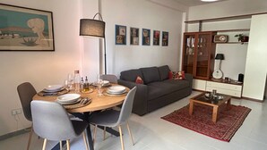 A dining area with a table set for four, a sofa, and a cabinet with glass doors. - Soleja House, 1000 meters from Poetto beach and Molentargius Park (Quartu Sant'Elena)