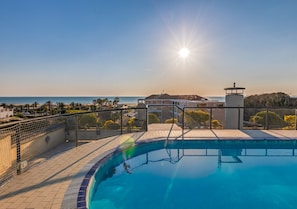 A swimming pool with a view of the ocean and a building in the background. - *Rooftop Pool* · Apartment 150m from the Sea (Marina di Pietrasanta)