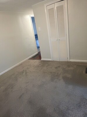 A hallway with carpeted flooring, white walls, and a white closet with louvered doors. - Fantastic 3-bedroom house with AC in charming Lebanon (Lebanon)