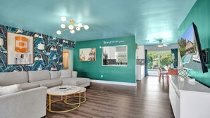 Una sala de estar moderna con un sofá modular, una mesa de centro y un televisor montado en la pared.
