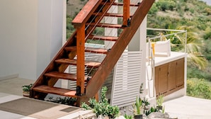 A modern multi-level house with a wooden staircase connecting the floors.