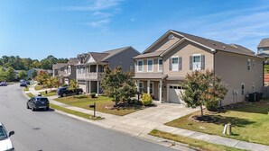 A residential street with two-story houses, a clear sky, and cars parked along the road. - 4BR/3BA, 3700 SqFt, Luxury Home in Durham near RDU, Duke, and UNC (Durham)