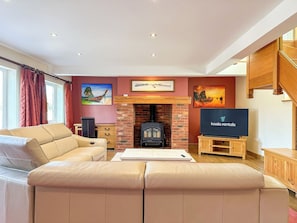 A living room with a sofa, fireplace, television, and artwork on the walls. - NEW - Ottersend Home w/ HotTub, Cinema & Fireplace (Chestfield)