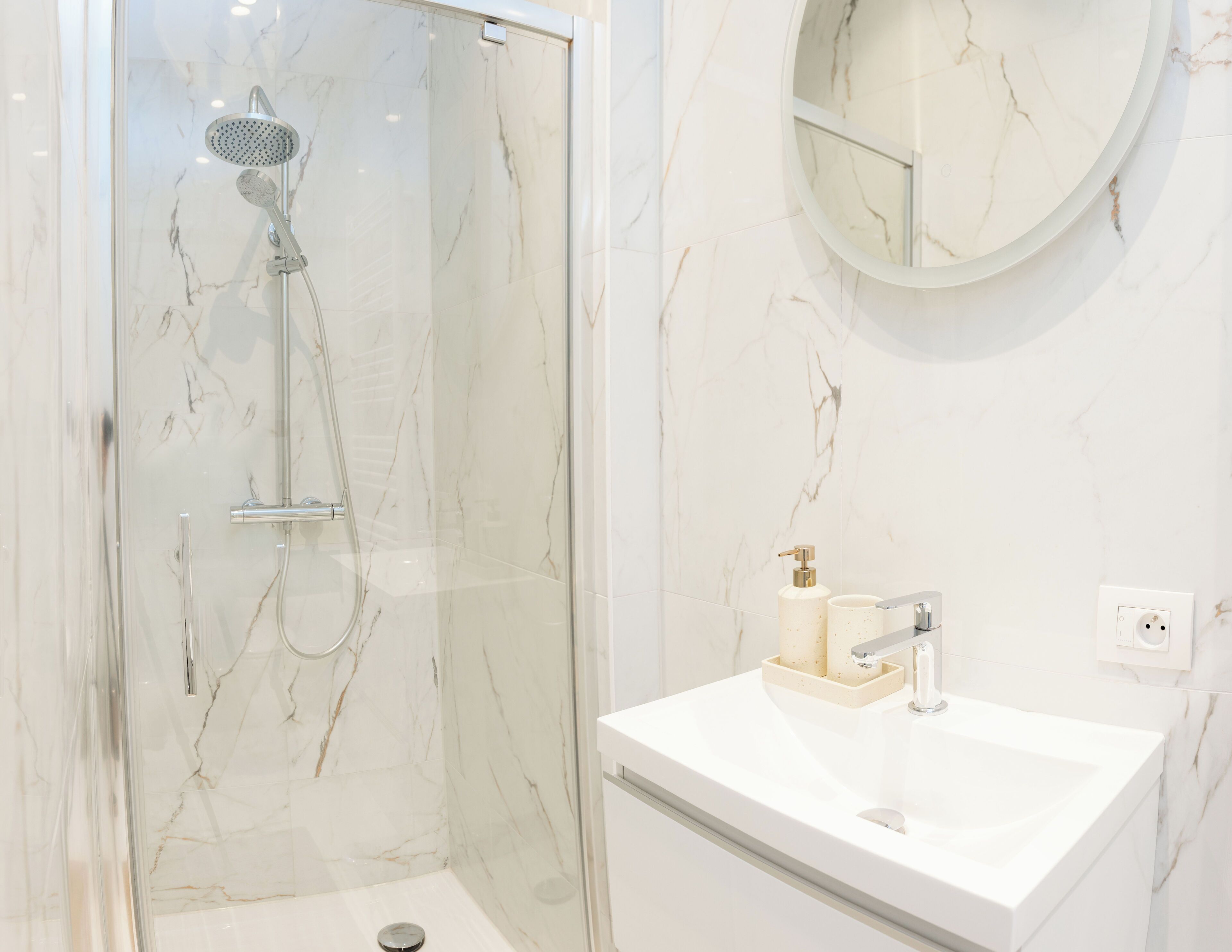 Une salle de bain avec une douche, un lavabo et un miroir.