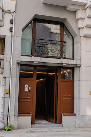 A building with a brown entrance, a balcony with ornate metal railings, and a number '4' on the door. - OneLuxStay Antwerp Near Central Station (Antwerp)