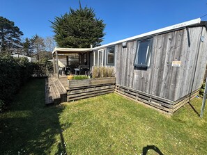 A mobile home with a patio area, a covered seating area, and a small deck. - 6-person mobile home rental with large water park (Carnac)
