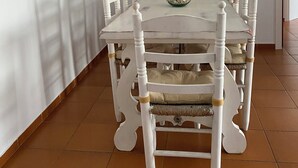 A dining area with a white table and chairs, a framed picture on the wall, and a mirror above the table. - Spacious apartment with ocean view, 2 steps from the beach, ideal for families! (L'Escala)