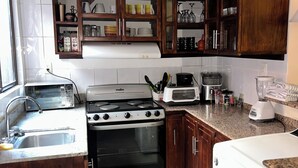 A kitchen with a stove, oven, microwave, and toaster.