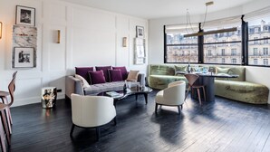 A modern living room with a sofa, chairs, a coffee table, and a dining area. - Victor Hugo Design - One Bedroom Apartment, Sleeps 2 (Paris)