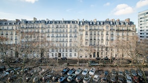 A row of multi-story buildings with a parking lot in front. - Victor Hugo Design - One Bedroom Apartment, Sleeps 2 (Paris)