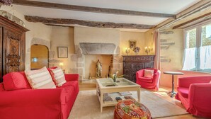 A cozy living room with red sofas, a glass coffee table, and a fireplace. - La Maison des Seigneurs les pieds dans l'eau (Le Conquet)