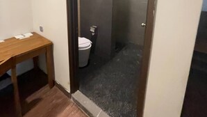 A narrow hallway leading to a bathroom with a toilet and a small table. - Perhentian Arwana Resort - Telok Dalam (Pulau Perhentian Besar)