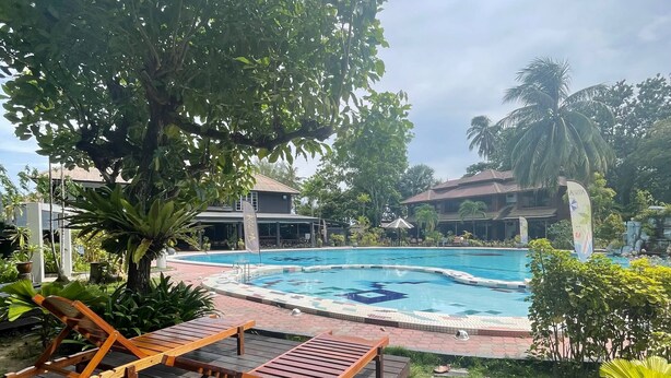 A pool area with lounge chairs, a tiled pool, and surrounding greenery. - Perhentian Arwana Resort - Telok Dalam (Pulau Perhentian Besar)