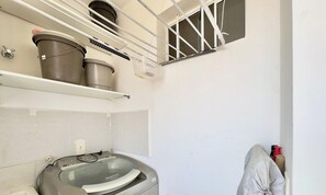 Casa de banho com banheira, chuveiro e janela com grades.