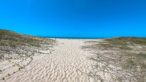 A sandy beach with dunes and a clear blue sky. - Beach Living Pe na Areia por Be My Guest (Aquiraz)