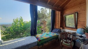 Eine Holzhütte mit einem Bett, einem Sessel und einem Tisch.