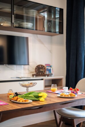 A breakfast table with croissants, a glass of orange juice, and a bowl of strawberries. - Luxury apartment in the center of town (Nice)