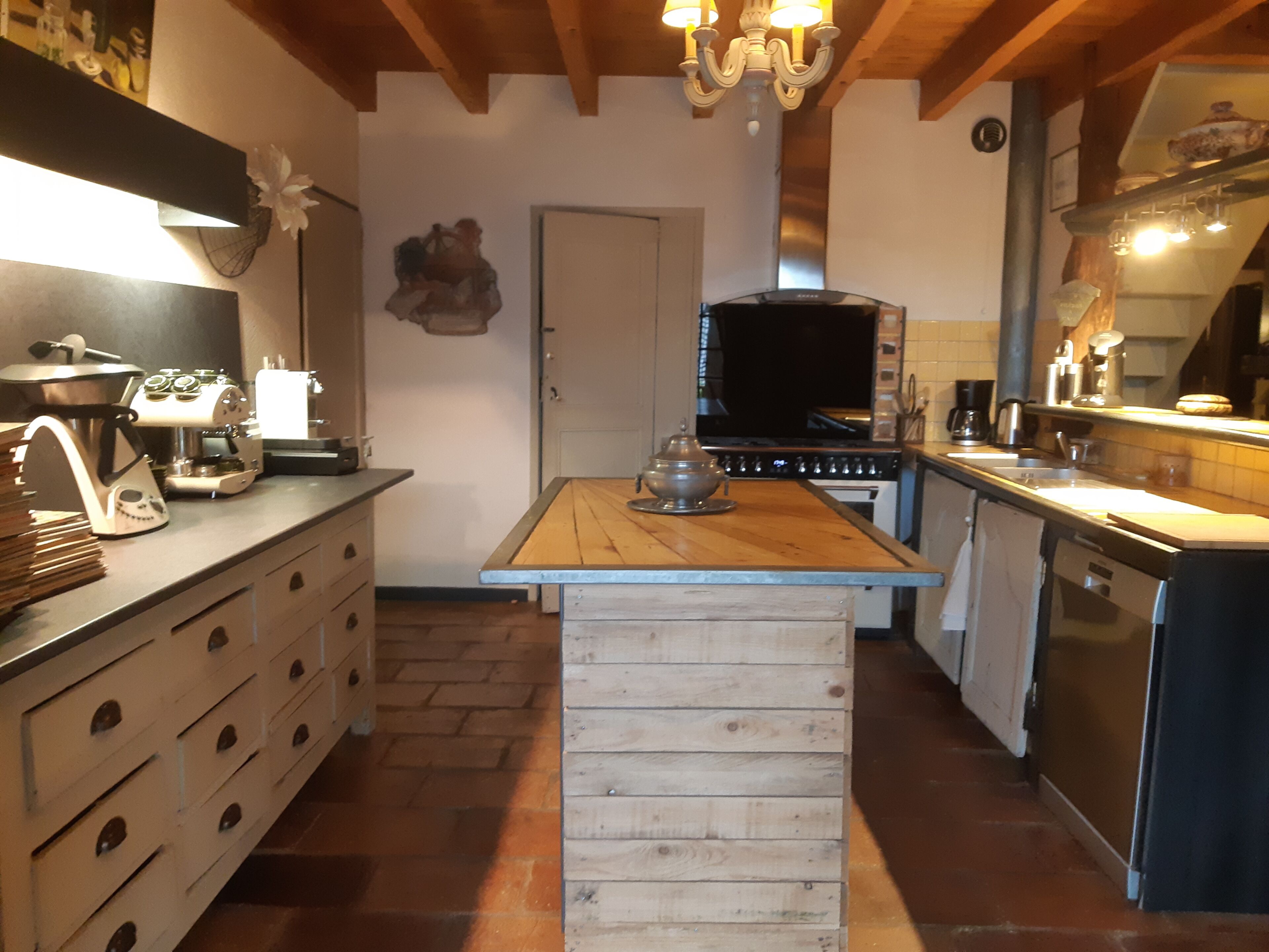 Une cuisine dotée d’un îlot central, de meubles en bois, d’une cuisinière et d’un évier.