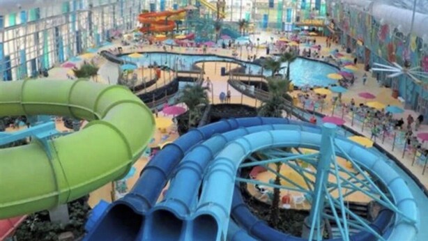 A large indoor water park with multiple water slides and a covered area. - BRAND NEW 3BR Coastal Retreat near OWA, shopping & min fr Gulf Shores beaches (Foley)