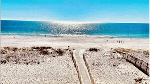 A beach with a wooden pathway leading to the water, a fence along the right side, and a clear sky. - BRAND NEW 3BR Coastal Retreat near OWA, shopping & min fr Gulf Shores beaches (Foley)