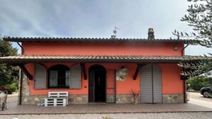 A single-story building with a tiled roof, a front door, and a small porch area. - Villa a stone's throw from Assisi with pool and barbecue, for a relaxing stay (Tordibetto)