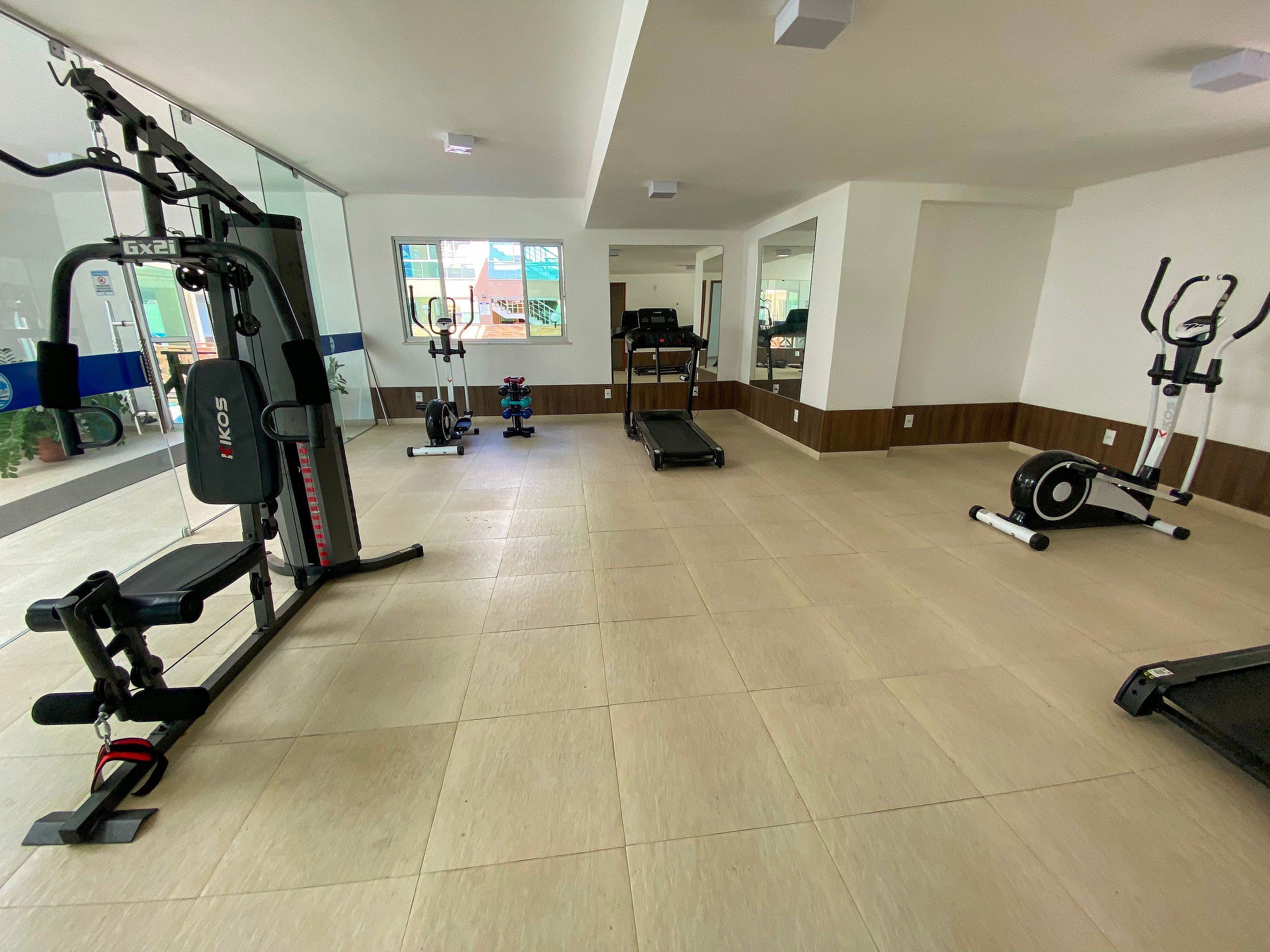 A gym with various exercise equipment, including a treadmill, stationary bike, and weight machines.