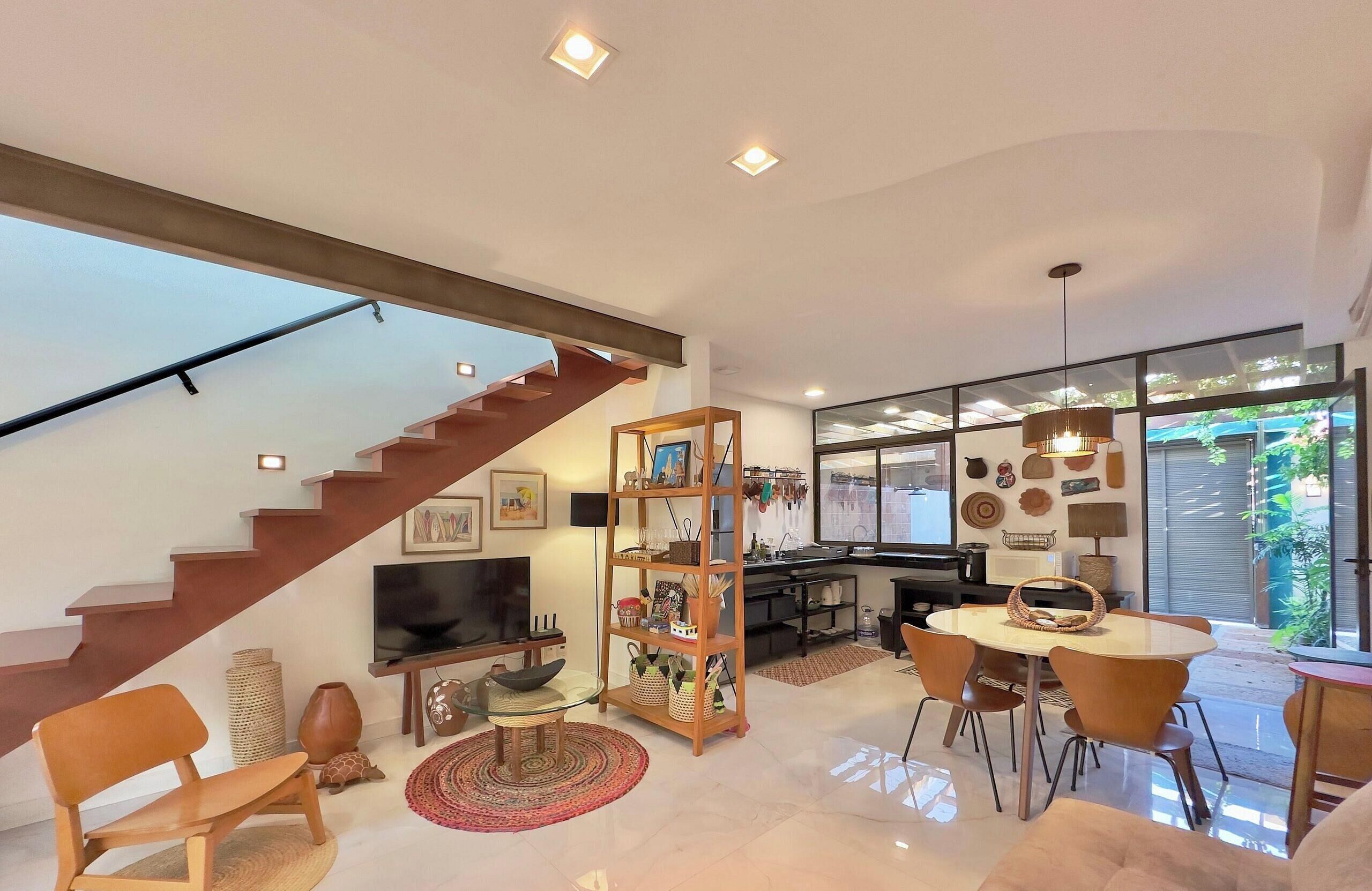 Un espacio moderno para vivir con escalera, comedor y cocina.